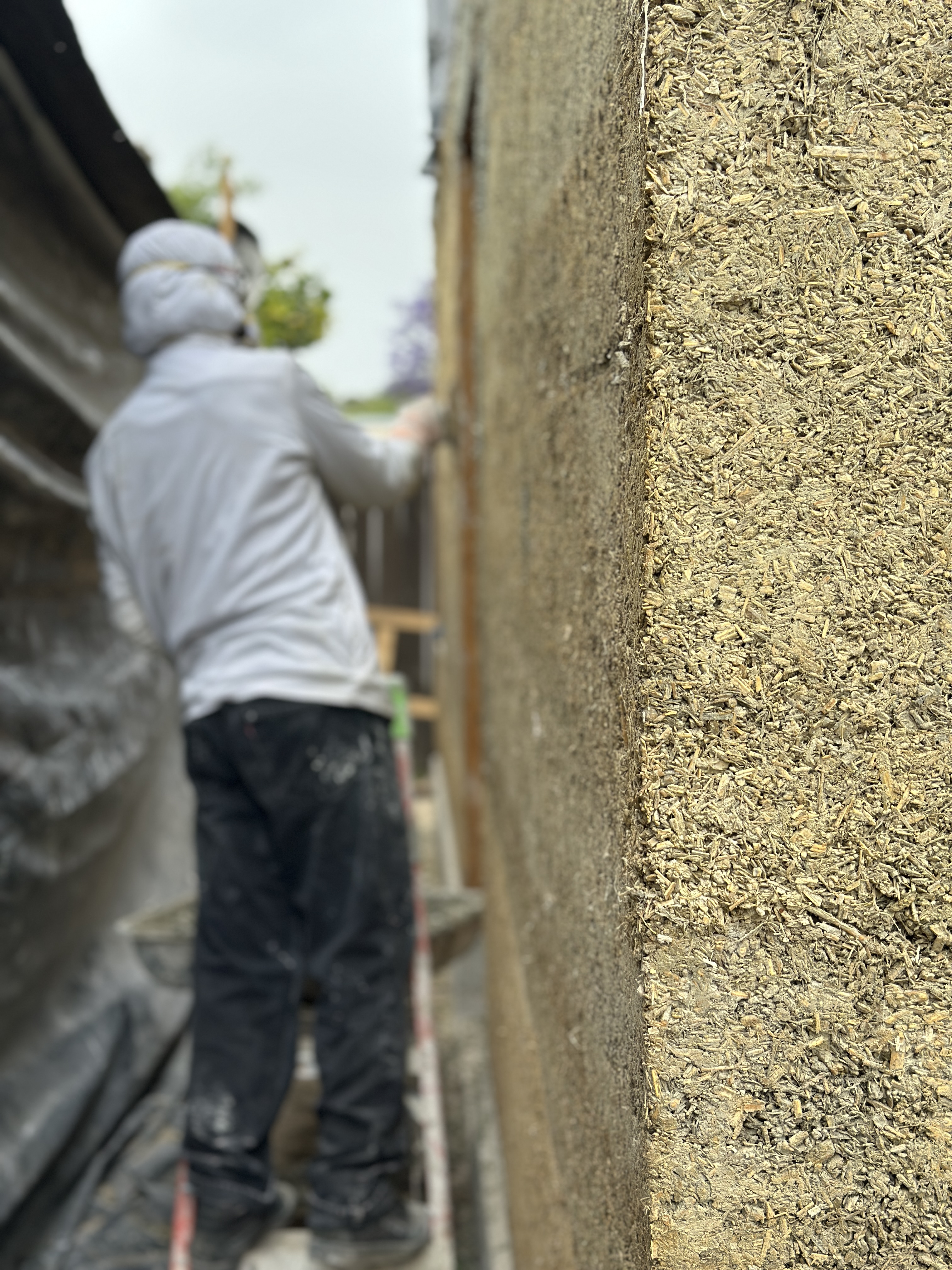 Builder tamping hempcrete into wall forms